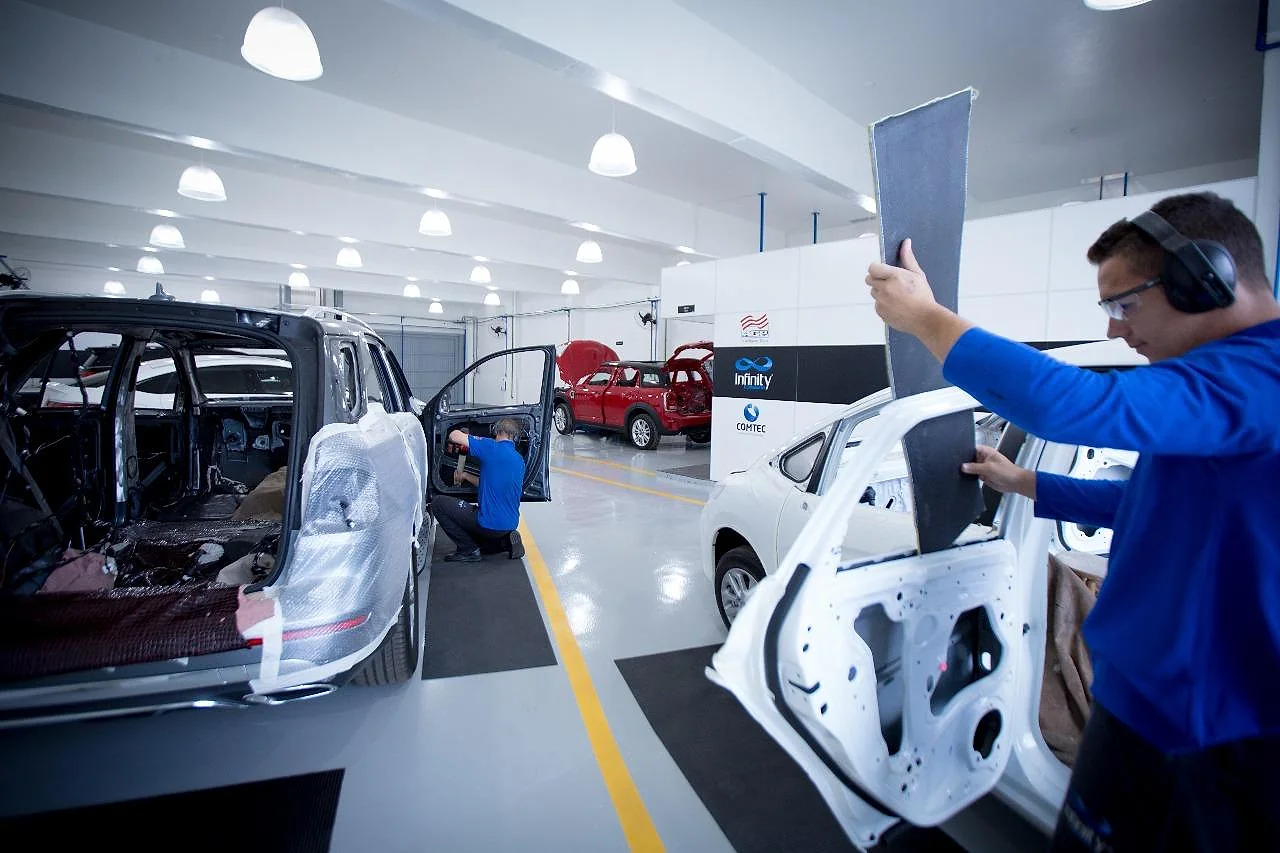 Técnicos manuseando manta balística antes da instalação