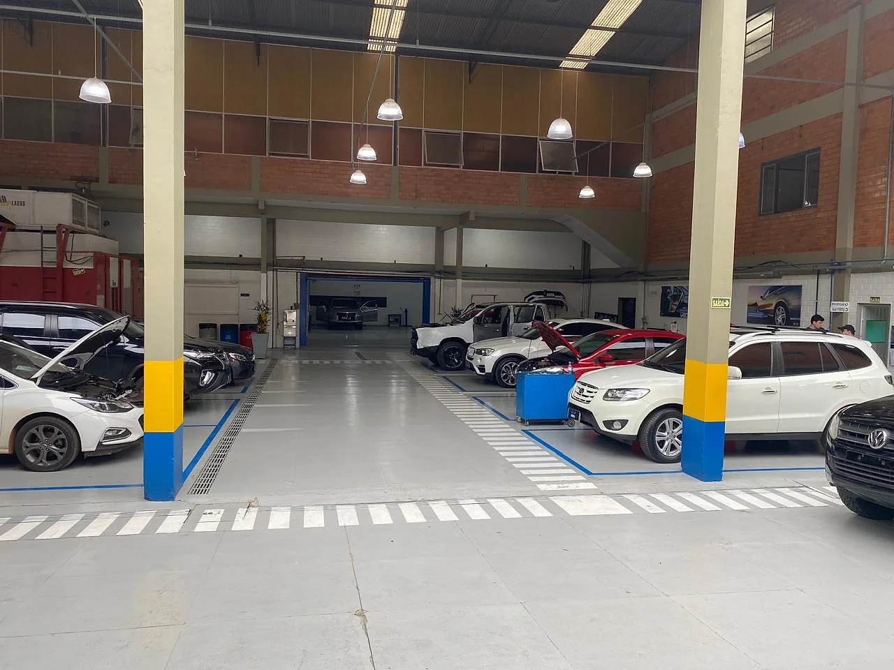 Carros em manutenção nos boxes do centro automotivo