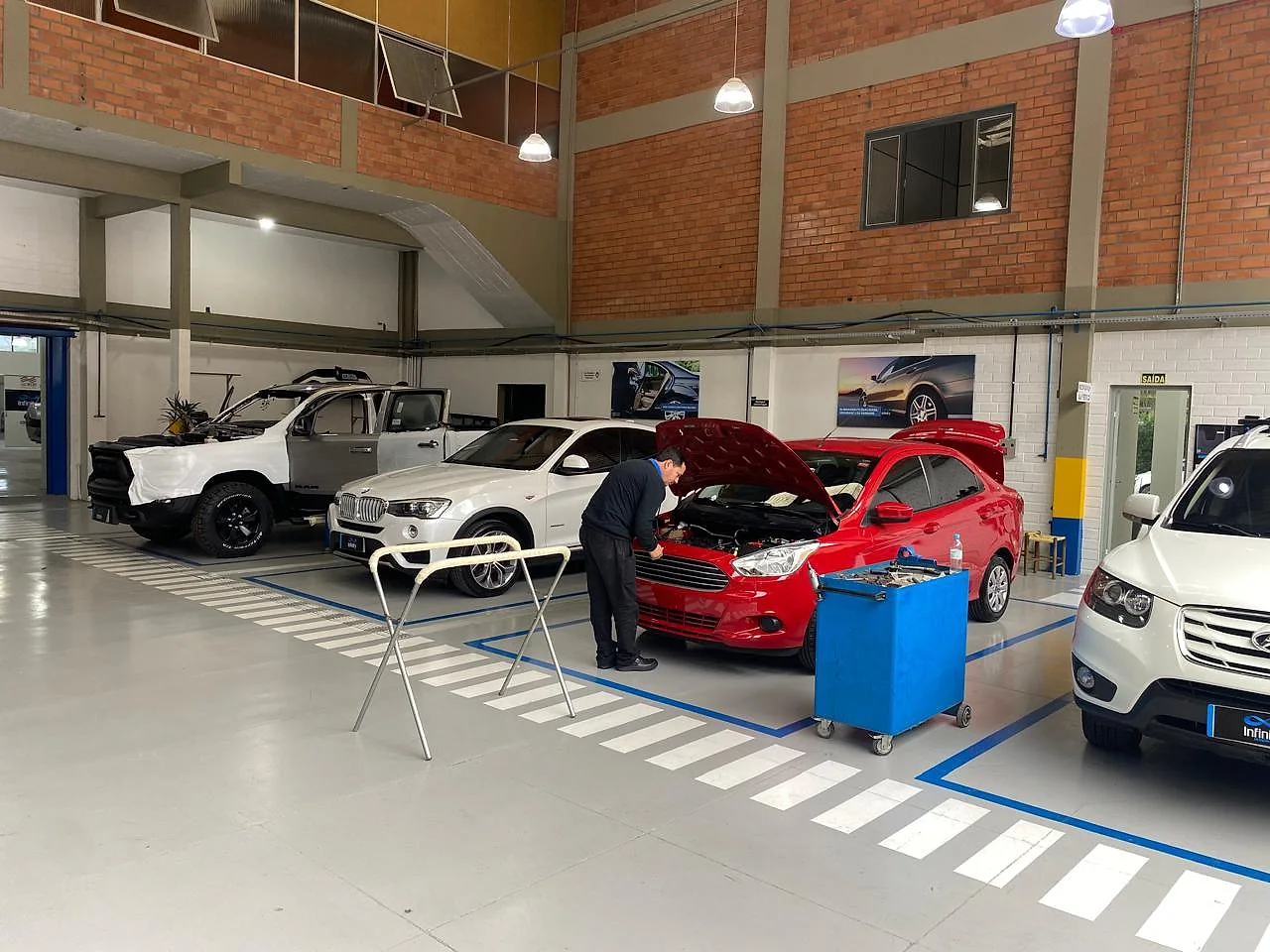 Mecânico trabalhando no motor de um carro na oficina